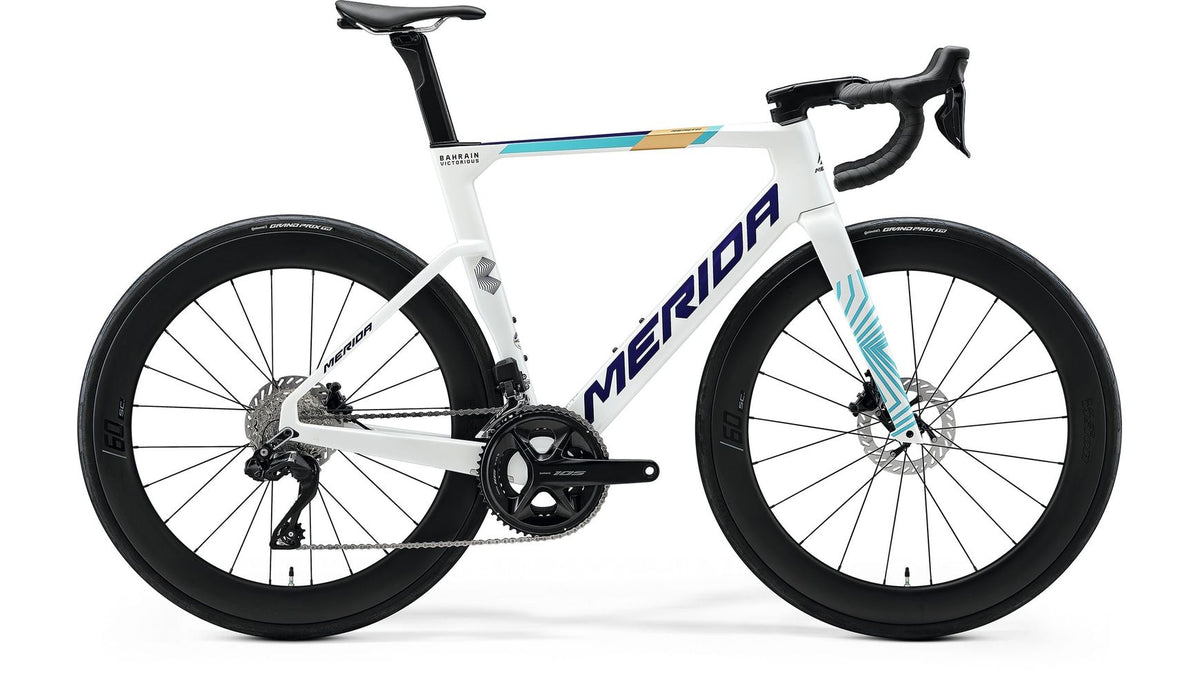 Ein weißes MERIDA Reacto 6000 Rennrad mit Carbonrahmen, schwarzen Laufrädern, tiefen Felgen, Scheibenbremsen und blau-gelben Akzenten wird im Seitenprofil vor weißem Hintergrund gezeigt.